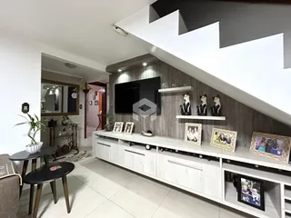 Sala de estar com painel de TV e estantes de madeira na decoração.
