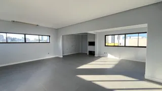 Sala ampla com piso claro e grandes janelas.