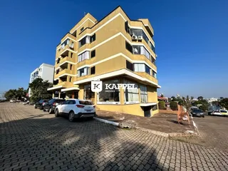 Foto da fachada de um prédio residencial em Lajeado, Brasil, com estacionamento em frente.