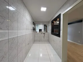 Corredor interno com revestimento de azulejos de mármore nas paredes.