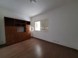 Quarto com armários em madeira e piso de madeira clara.
