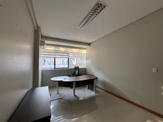 Interior de uma sala com piso de cerâmica e janela.