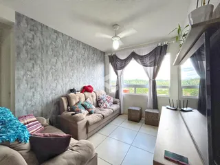 Sala de estar com sofá e janela em um imóvel no Brasil.