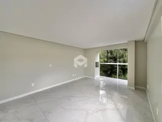 Vista interna de uma sala ampla com piso de porcelanato claro.