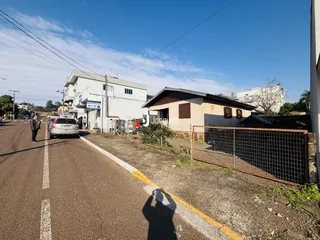 Vista da fachada de duas casas em Lajeado, Brasil, ao longo de uma rua.