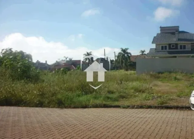 Vista externa de uma propriedade com grama e área pavimentada na frente.