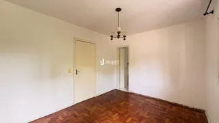 Hall de entrada com piso de madeira e portas brancas.