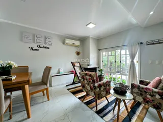 Sala de estar com piso de porcelanato e vista para o exterior.