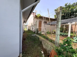 Vista lateral de uma propriedade com cerca e vegetação.