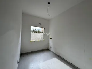 Vista interna de um ambiente com paredes brancas e piso claro.