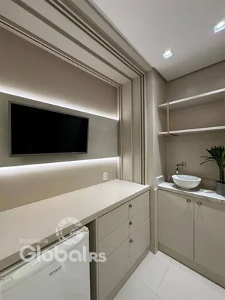 Ambiente moderno com painel de TV e armários em uma sala de estar.