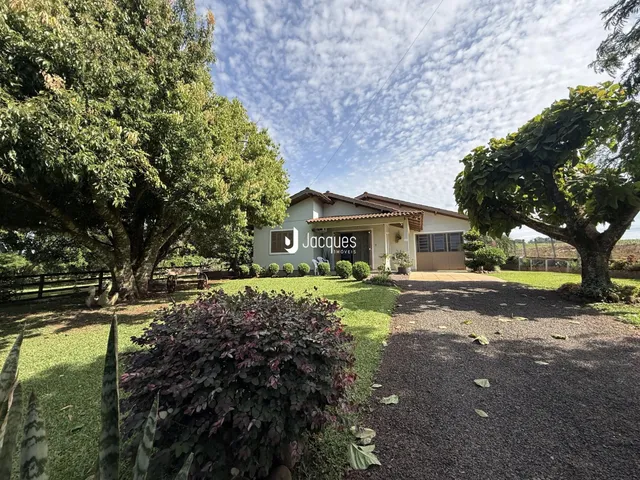 A fachada de uma casa em Lajeado, Brasil, cercada por árvores e gramado.