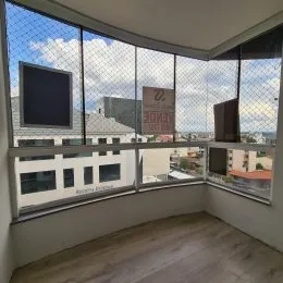 Sala de estar com grandes janelas que proporcionam uma vista da paisagem urbana.