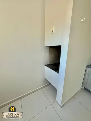 Parede interna com um nicho e piso de cerâmica em um ambiente residencial.
