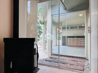 Vista de uma sala de estar com porta de vidro para uma área externa.