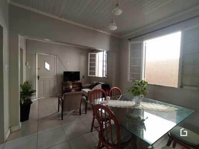 Sala de estar com mesa de vidro e móveis de madeira.