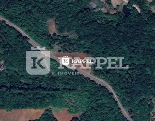 Vista aérea de uma área com vegetação densa e terrenos abertos.