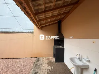 Foto de um ambiente interno com estrutura de teto de madeira e uma pia na parede.