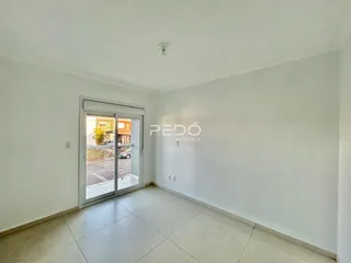 Vista interna de um ambiente com piso de cerâmica e porta de vidro.