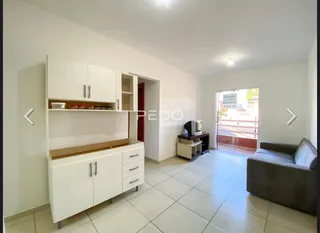 Sala de estar com armários brancos e piso de cerâmica.