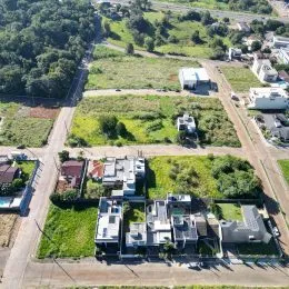 Vista aérea de um terreno com área verde e estruturas residenciais.