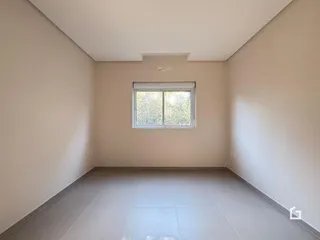 Ambiente interno de uma sala com piso de cerâmica e janela.