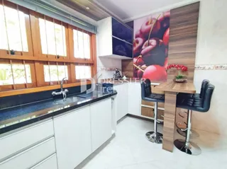 Sala de estar com janelas grandes e acabamentos em madeira.