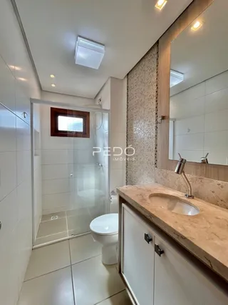 Foto de um banheiro interno com azulejos brancos e bancada de pedra.