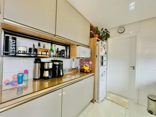 Cozinha com armários de madeira e bancada clara.