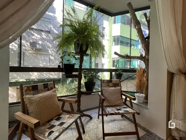 Vista de uma sala com móveis de madeira e plantas em um apartamento em Lajeado.