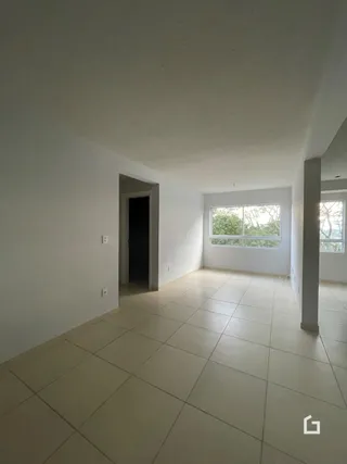 Vista interna de um ambiente com piso de cerâmica clara e paredes brancas.