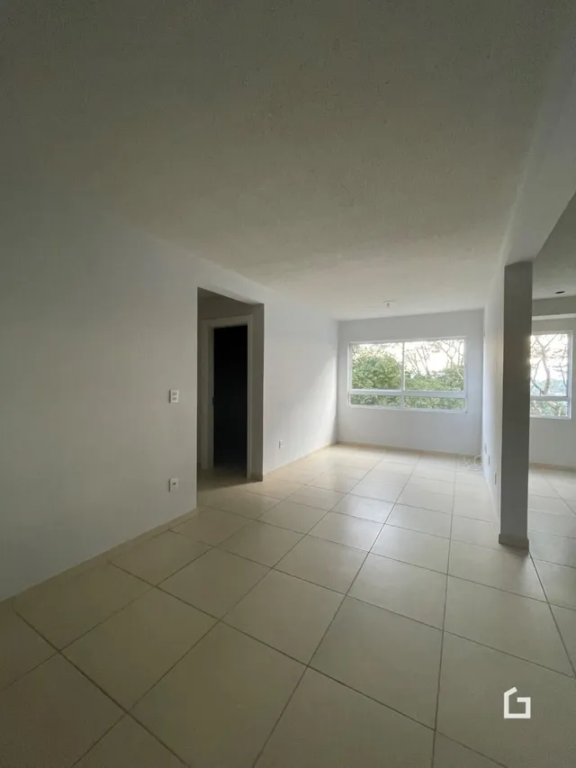 Vista interna de um ambiente com piso de cerâmica clara e paredes brancas.