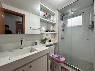 Foto de um banheiro moderno com box de vidro e revestimento branco.