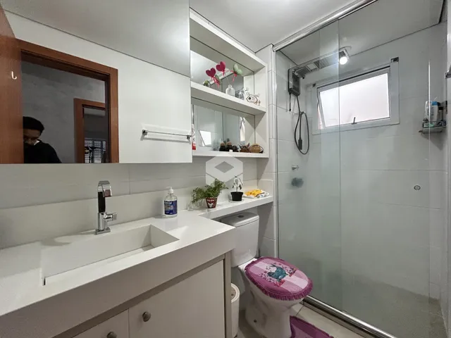 Foto de um banheiro moderno com box de vidro e revestimento branco.