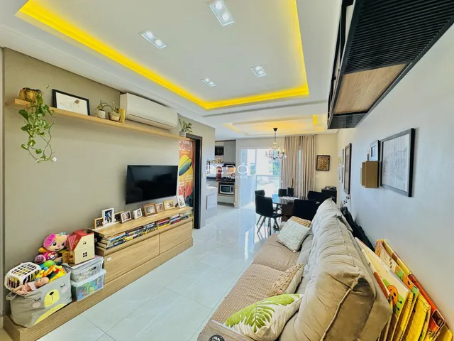 Sala de estar moderna com decoração de madeira e televisão.