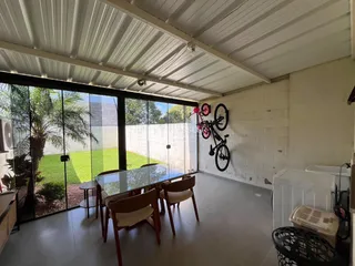 Vista de uma sala de jantar com porta de vidro e área externa.