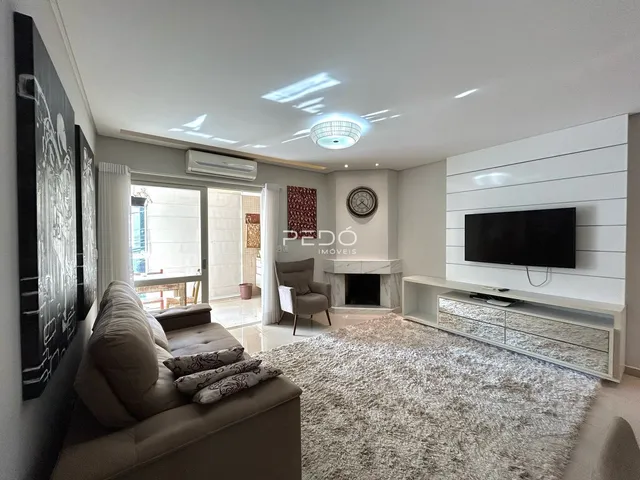 Sala de estar moderna com sofá e lareira em um apartamento no Brasil.