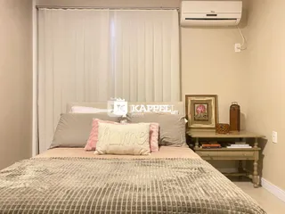 Foto de um quarto com cama e cortinas brancas.