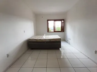Quarto com cama e janela em ambiente claro.
