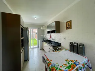 Interior de uma sala de estar com cozinha e quarto em um imóvel no Brasil.