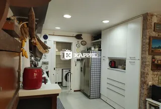 Foto de uma cozinha com armários brancos e eletrodomésticos.