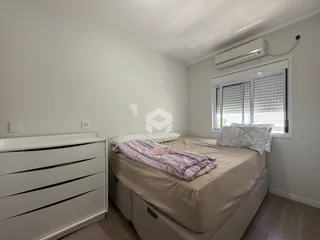 Quarto com cama e cômoda brancos em um imóvel.