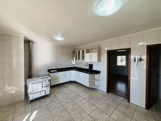 Foto de uma cozinha com armários brancos e piso de cerâmica.