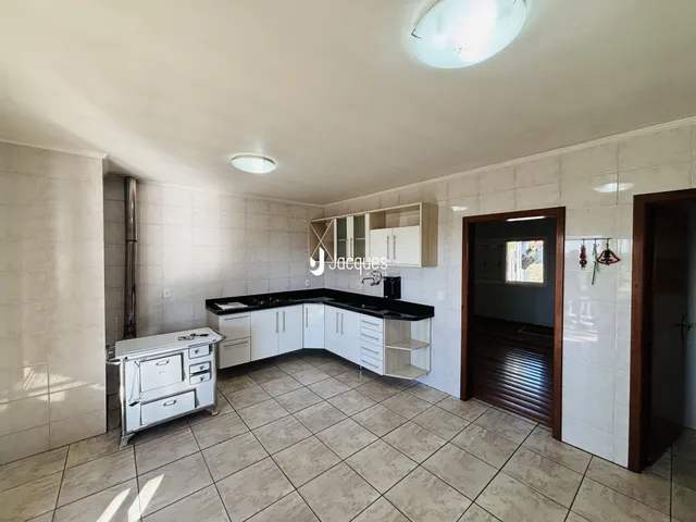 Foto de uma cozinha com armários brancos e piso de cerâmica.