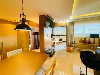 Sala de estar com piso claro e detalhes em madeira em um imóvel em Lajeado.