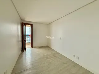 Hall de entrada com piso de madeira clara e paredes brancas.