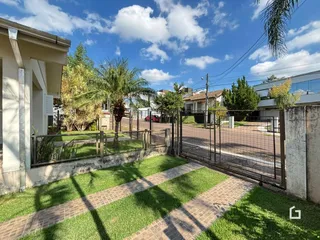Vista externa da propriedade com cerca e jardim.