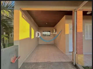 Vista de um corredor interno com teto de madeira e paredes amarelas.