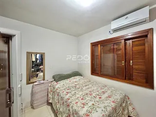 Quarto com armário de madeira e cama decorada.