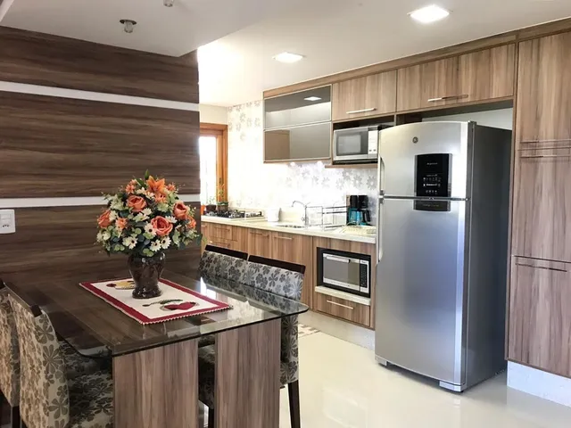 Vista de uma sala de jantar integrada com cozinha moderna em um imóvel.